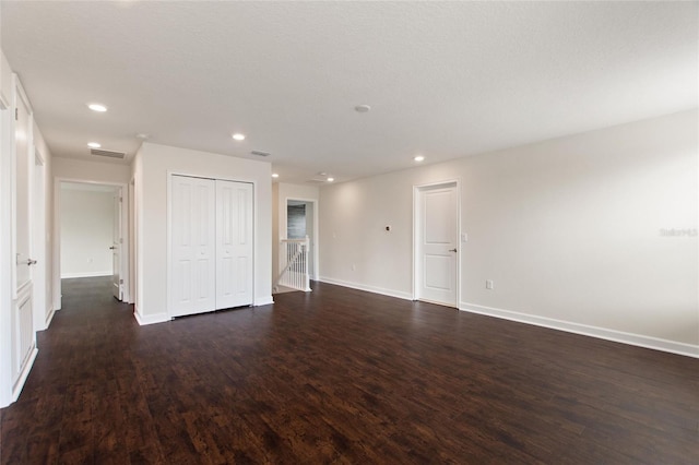 empty room with dark wood-type flooring and a textured ceiling