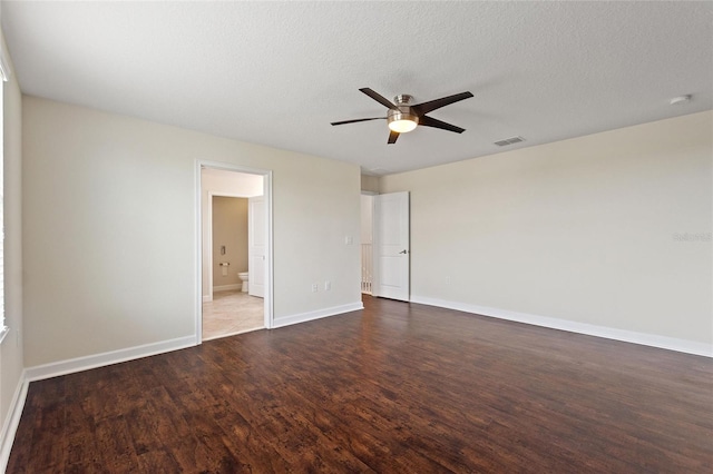 empty room with ceiling fan, a textured ceiling, and dark hardwood / wood-style flooring