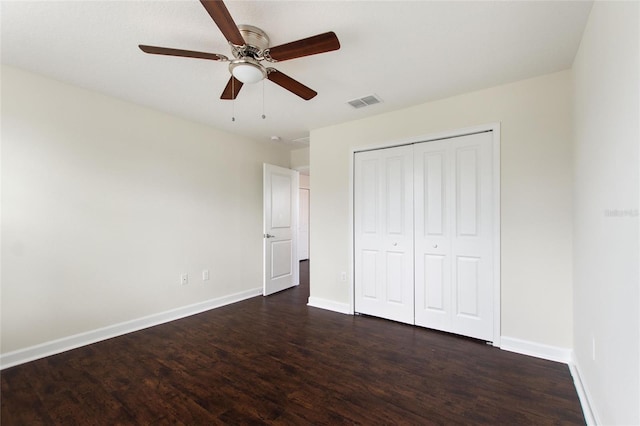 unfurnished bedroom with ceiling fan, dark hardwood / wood-style floors, and a closet