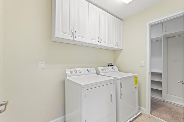 laundry room with cabinets, light colored carpet, and washing machine and clothes dryer