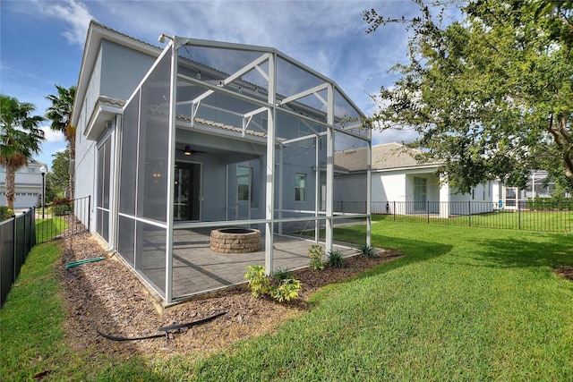 back of house featuring a patio area, ceiling fan, a lanai, a fire pit, and a lawn