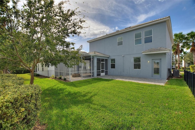 rear view of house featuring central AC unit, a patio, a sunroom, and a yard