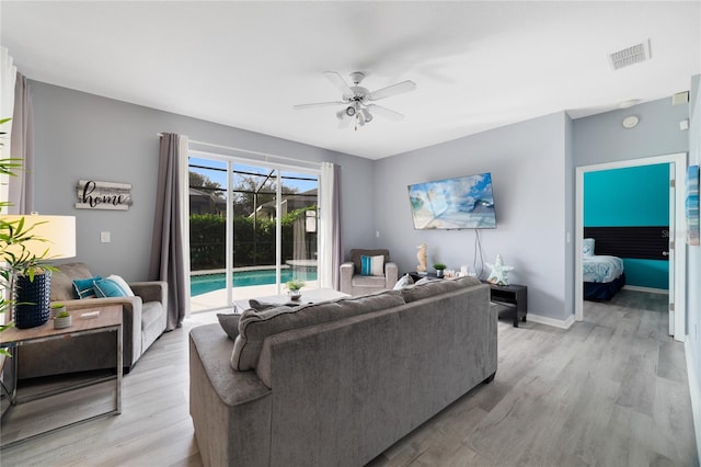 living room with light wood-type flooring and ceiling fan