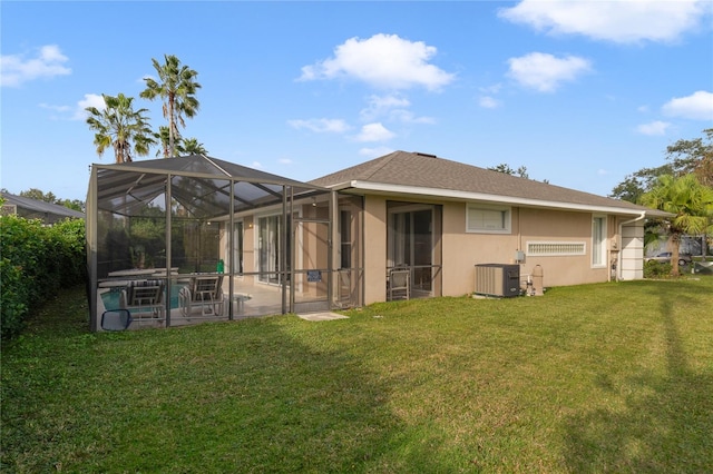 back of house with a lawn, central AC, and glass enclosure