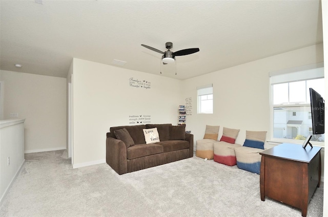 living room with ceiling fan, a healthy amount of sunlight, and light colored carpet