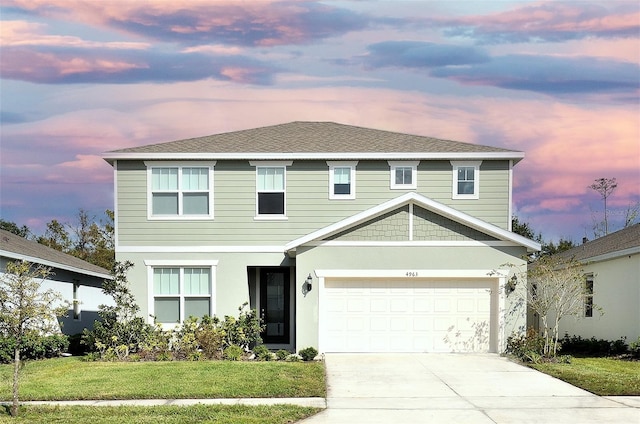 view of front facade with a lawn and a garage