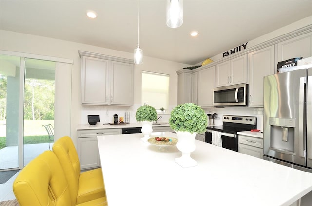 kitchen featuring stainless steel appliances, backsplash, pendant lighting, gray cabinets, and a kitchen island