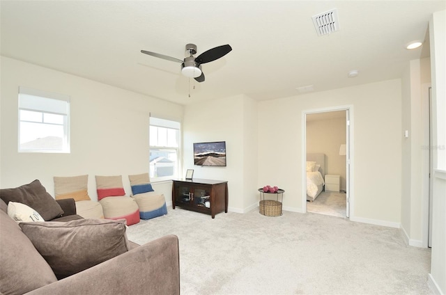 carpeted living room with ceiling fan and a healthy amount of sunlight