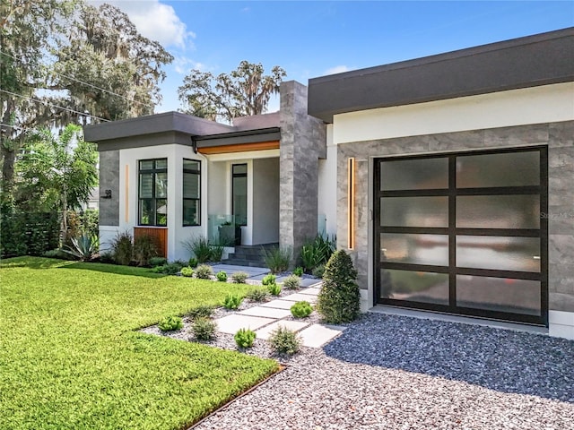 property entrance featuring a garage and a lawn