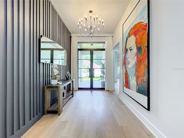 entryway with an inviting chandelier and light wood-type flooring