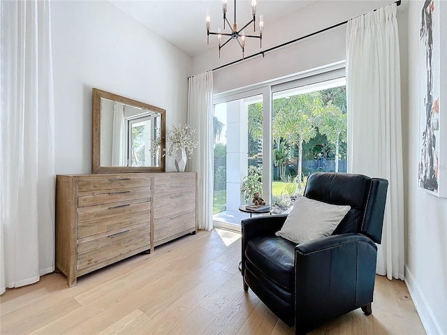 living area featuring light hardwood / wood-style flooring, a chandelier, and plenty of natural light