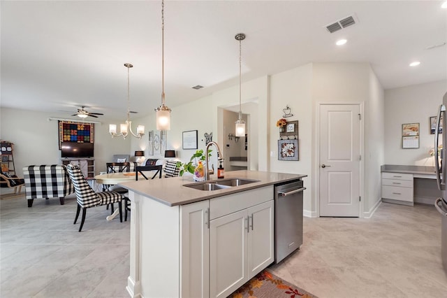 kitchen with hanging light fixtures, sink, an island with sink, ceiling fan, and white cabinetry