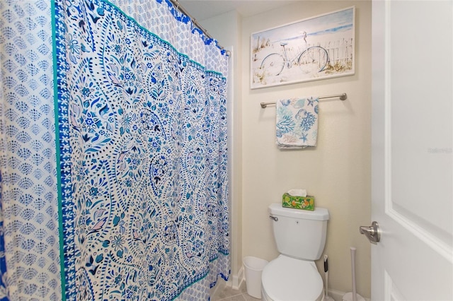 bathroom with toilet, tile patterned floors, and walk in shower