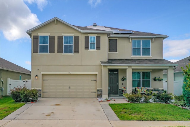 1927 Partin Terrace Rd, Kissimmee, FL 34744 - view of front of property featuring stucco siding, covered porch, solar panels, concrete driveway, and a garage