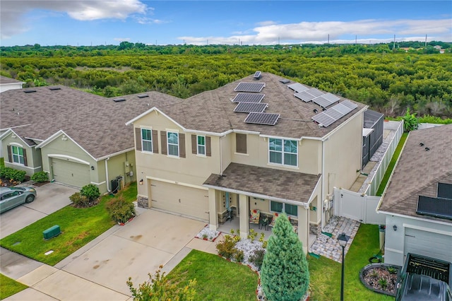 1927 Partin Terrace Rd, Kissimmee, FL 34744 - view of front facade with stucco siding, a shingled roof, solar panels, and concrete driveway