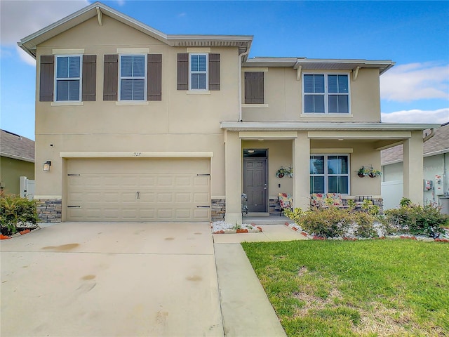 1927 Partin Terrace Rd, Kissimmee, FL 34744 - view of front facade featuring stucco siding, covered porch, driveway, a garage, and a front yard