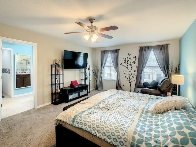 carpeted bedroom featuring ceiling fan and ensuite bath