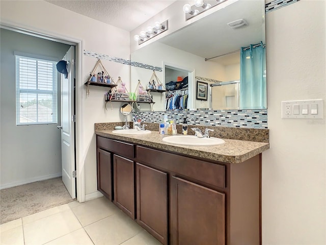 bathroom featuring tile patterned flooring, a textured ceiling, vanity, backsplash, and a shower