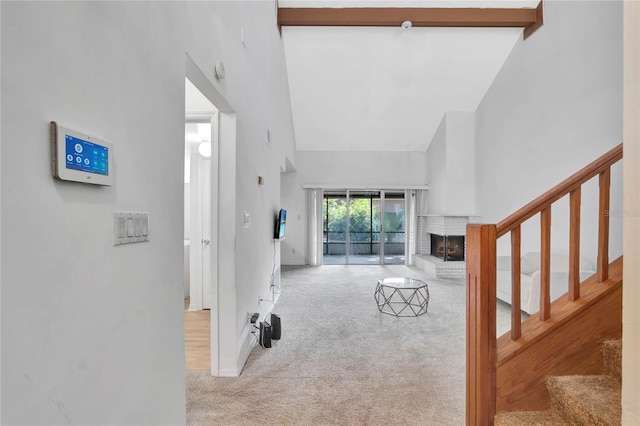 living room featuring a fireplace, beam ceiling, light carpet, and high vaulted ceiling