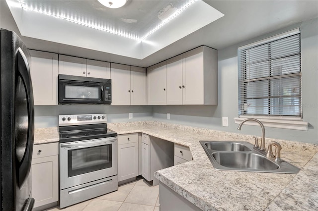 kitchen featuring sink, light tile patterned floors, and black appliances