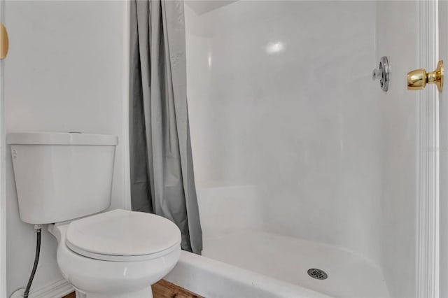 bathroom featuring a shower with curtain and toilet