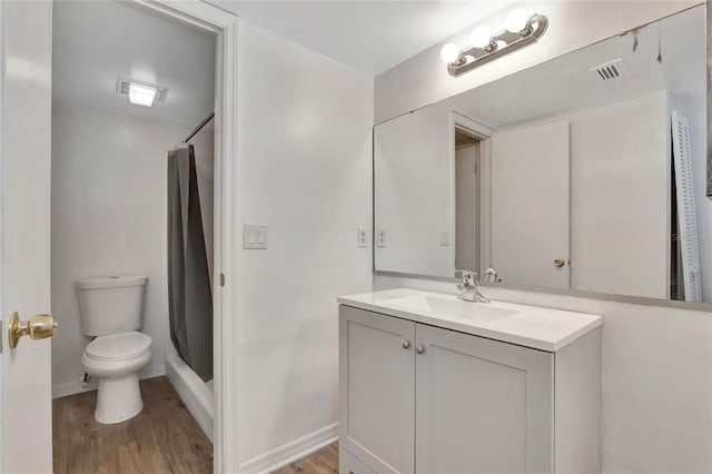 bathroom with a shower with curtain, vanity, hardwood / wood-style flooring, and toilet