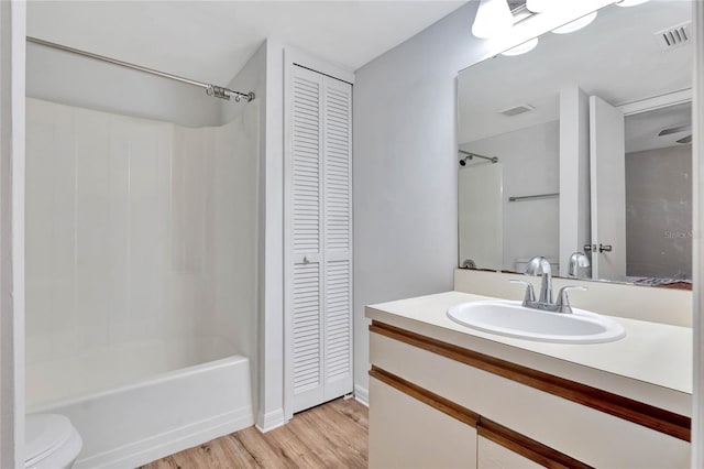 full bathroom with vanity, toilet, wood-type flooring, and washtub / shower combination