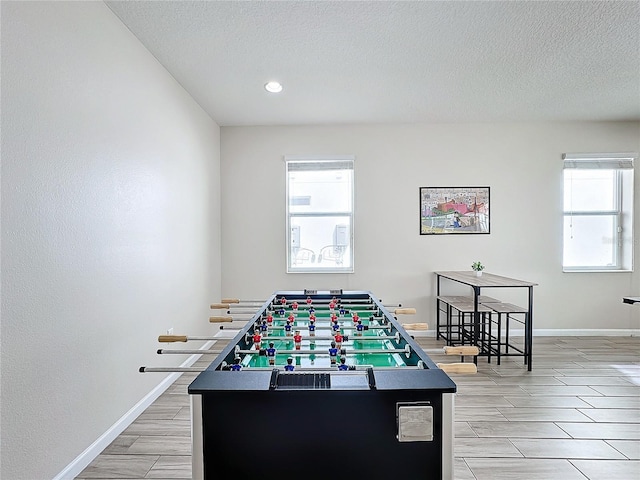 rec room featuring light hardwood / wood-style floors and a textured ceiling