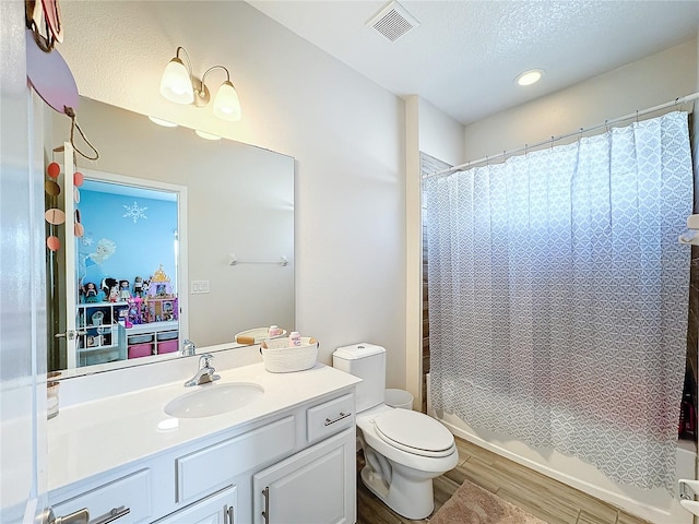 full bathroom featuring toilet, shower / bath combination with curtain, a textured ceiling, and hardwood / wood-style flooring