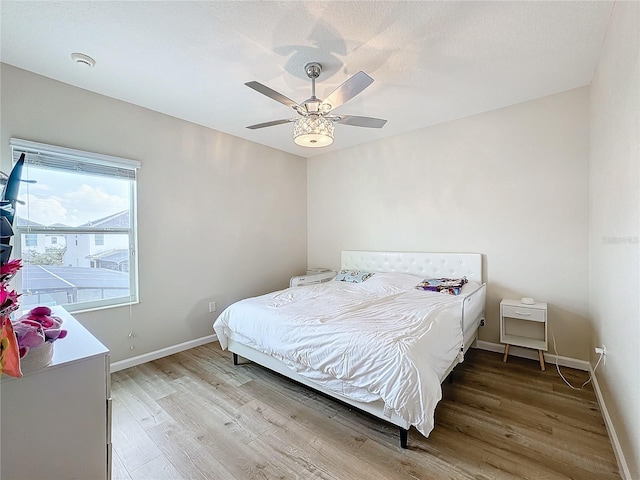 bedroom with ceiling fan and wood-type flooring