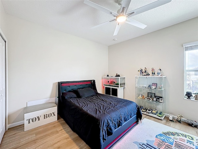 bedroom featuring hardwood / wood-style floors, ceiling fan, and a textured ceiling