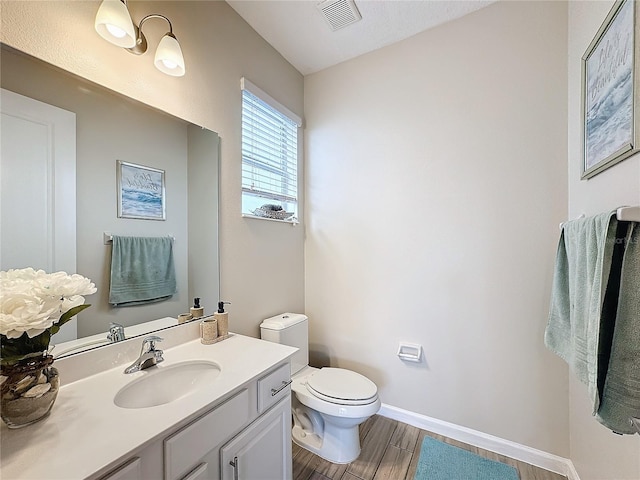 bathroom with vanity, wood-type flooring, and toilet