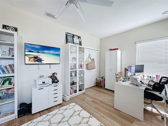 office with ceiling fan, light hardwood / wood-style floors, and a textured ceiling