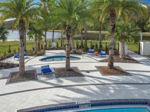 view of pool featuring an in ground hot tub, a patio, and a water view