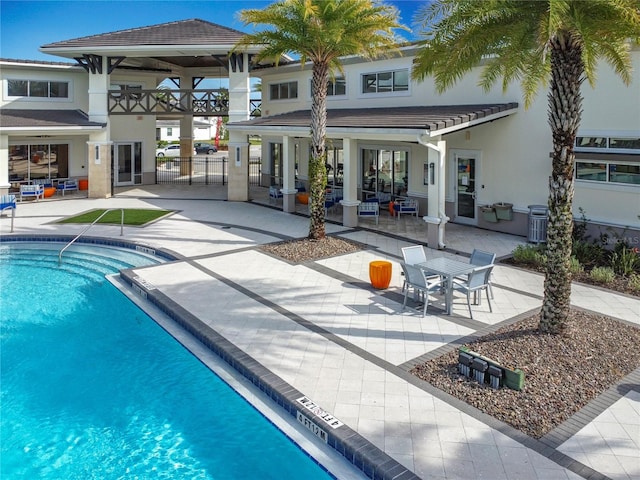 rear view of property with a patio and a community pool