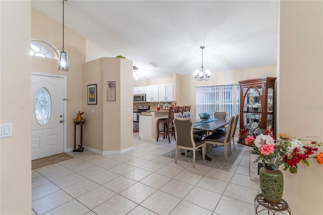 tiled entrance foyer with an inviting chandelier