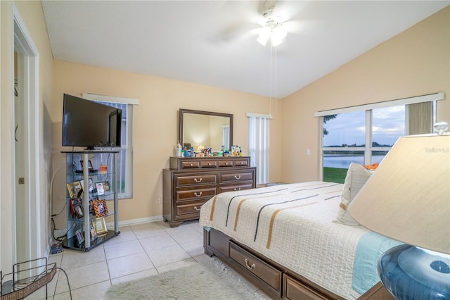 tiled bedroom with ceiling fan, a water view, and vaulted ceiling