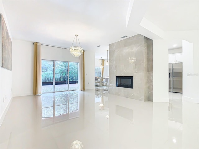 living room with a fireplace, light tile patterned floors, and an inviting chandelier