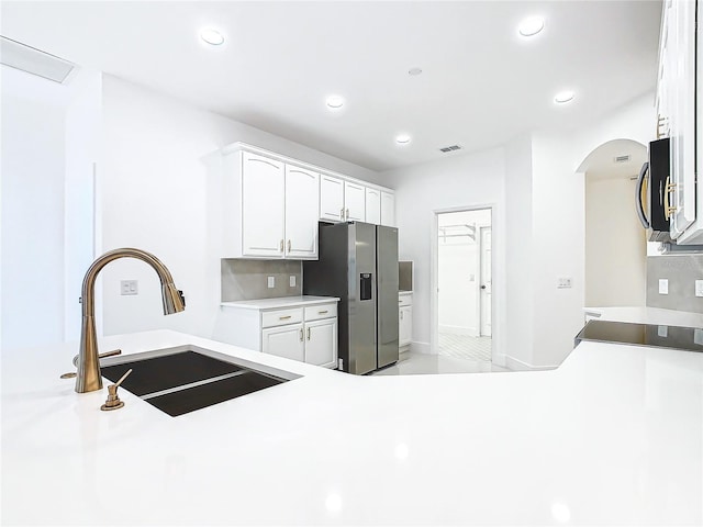 kitchen featuring decorative backsplash, stainless steel appliances, white cabinetry, and sink