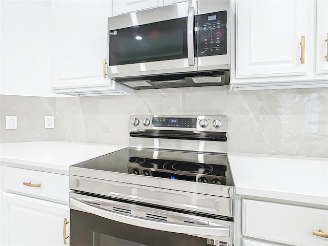 kitchen featuring decorative backsplash, white cabinetry, and appliances with stainless steel finishes