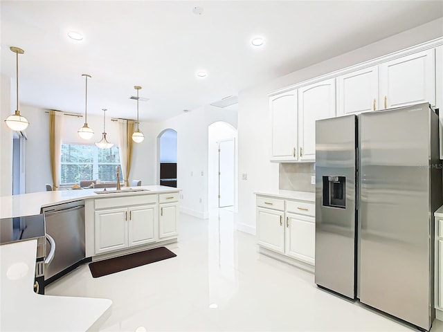 kitchen with sink, hanging light fixtures, decorative backsplash, white cabinets, and appliances with stainless steel finishes