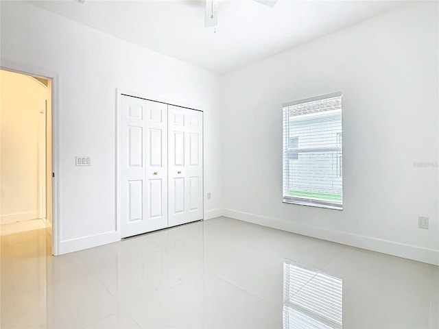 unfurnished bedroom with ceiling fan, a closet, and light tile patterned flooring