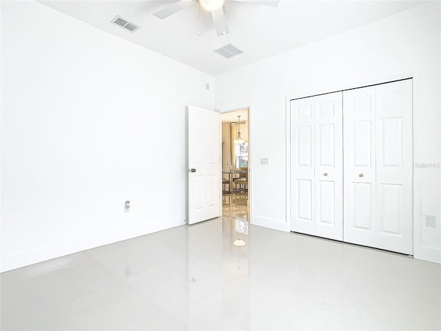 unfurnished bedroom with concrete flooring, a closet, and ceiling fan