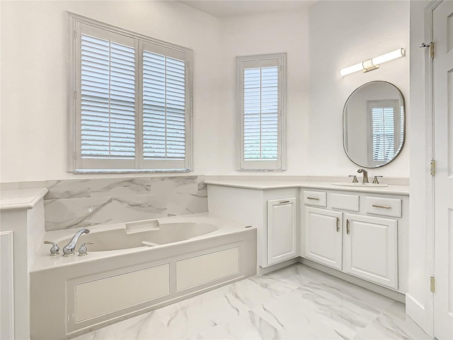 bathroom with a tub to relax in, a wealth of natural light, and vanity