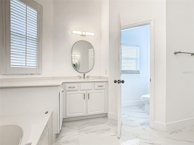 bathroom with a bath, vanity, and toilet