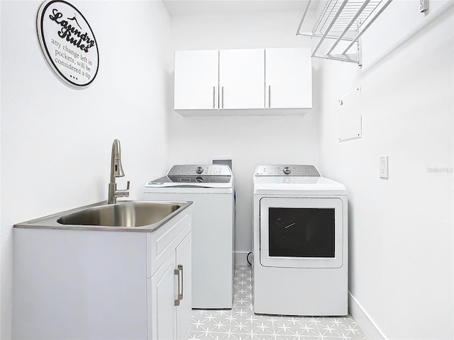 laundry area with cabinets, light tile patterned flooring, washing machine and dryer, and sink