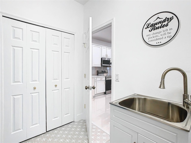 kitchen with white cabinets, appliances with stainless steel finishes, and sink