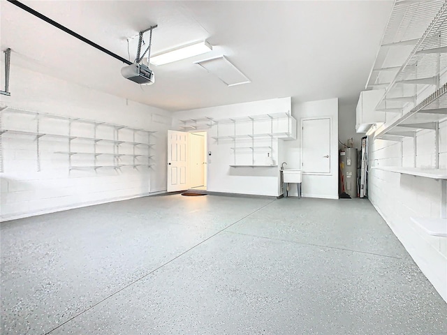 garage with electric water heater, sink, and a garage door opener