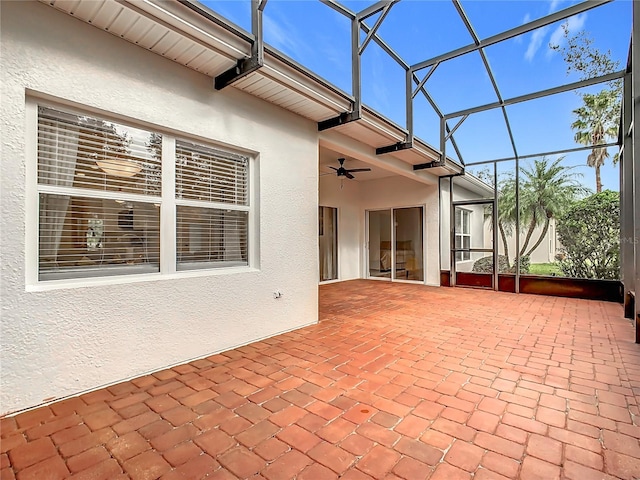 view of patio featuring glass enclosure and ceiling fan