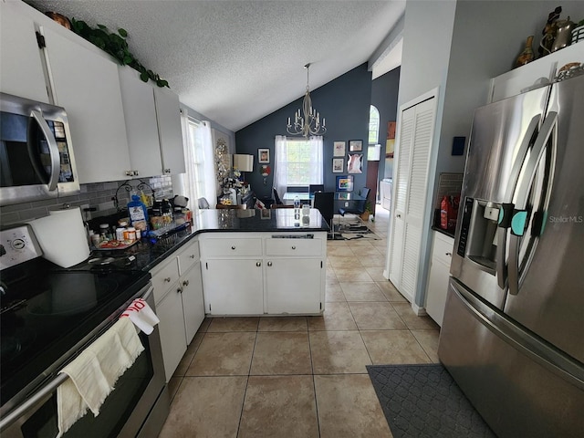 kitchen featuring white cabinets, kitchen peninsula, stainless steel appliances, and a textured ceiling